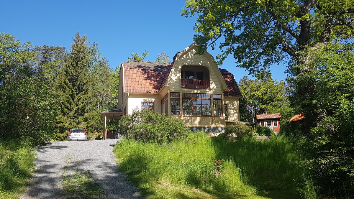 Idyllisk villa med sjöutsikt, brygga och båt.