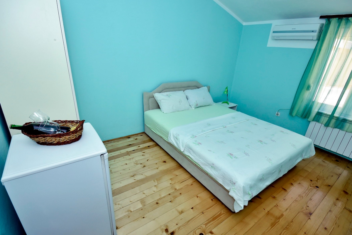 绿色房间，配有双人床和共用卫生间