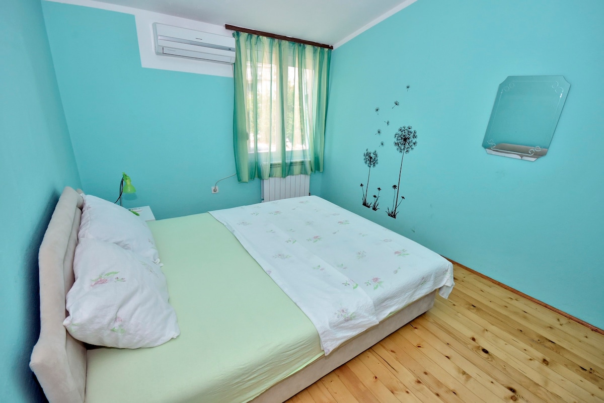 绿色房间，配有双人床和共用卫生间