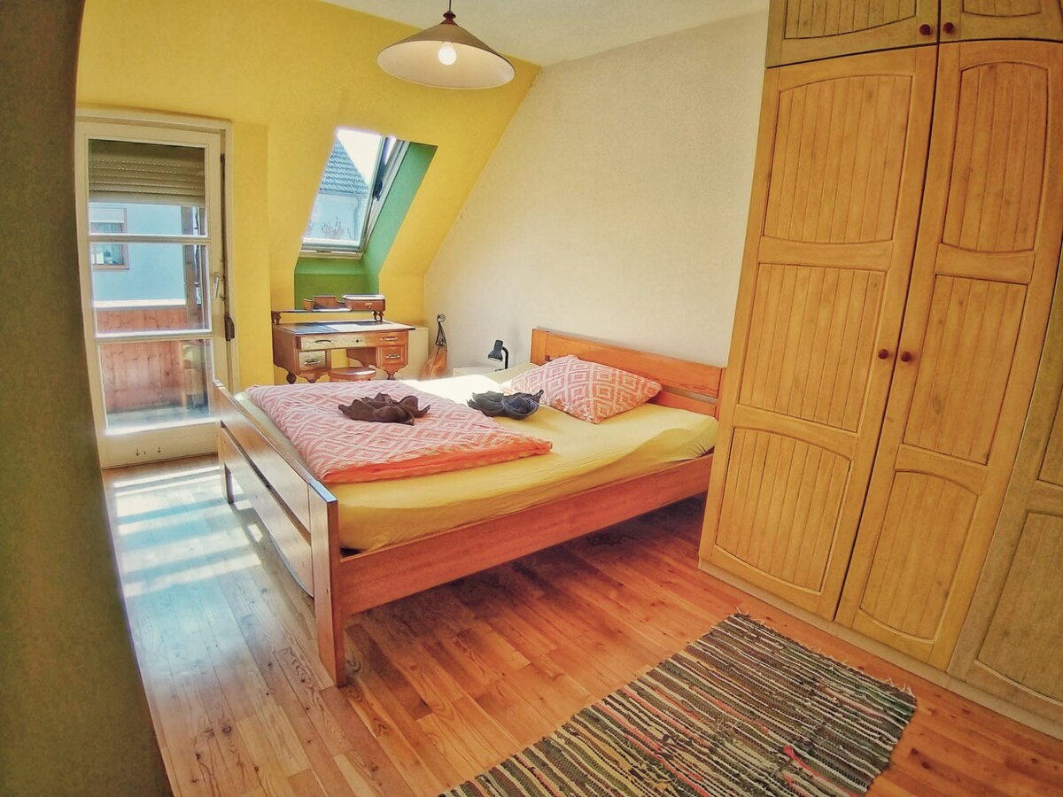 阳光明媚的房间，配有标准双人床和阳台