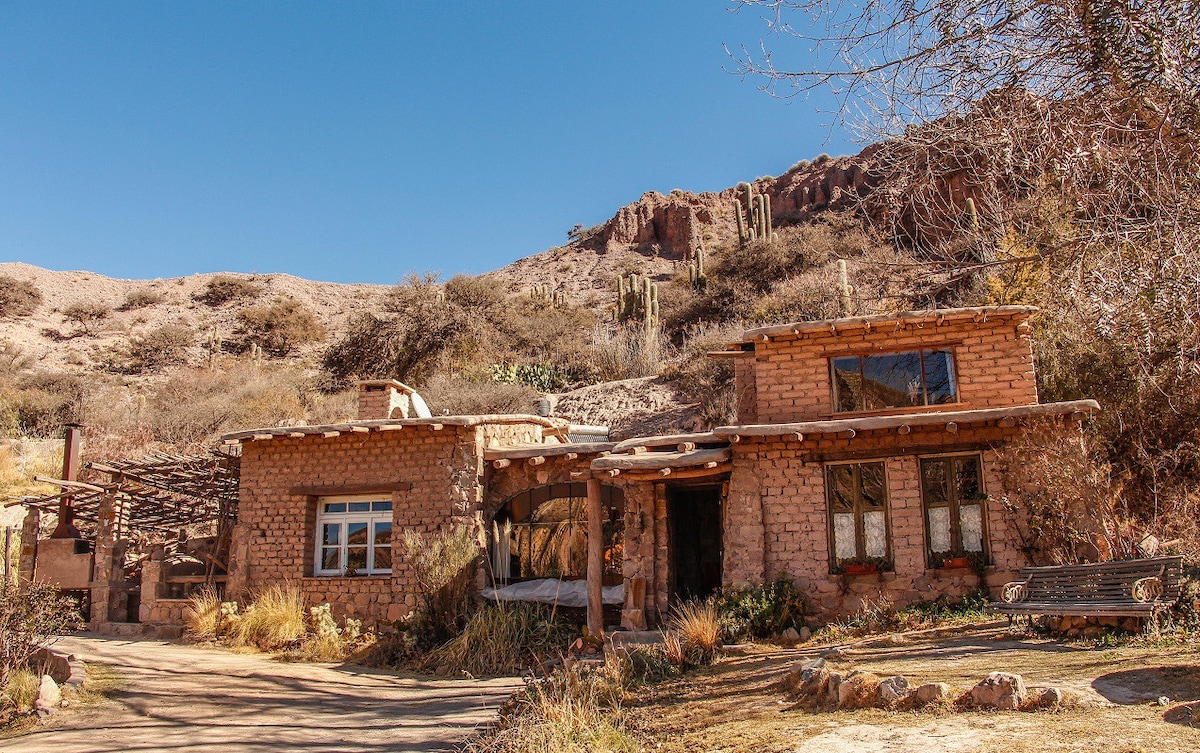 Casa de campo entre frutales y cerros de colores