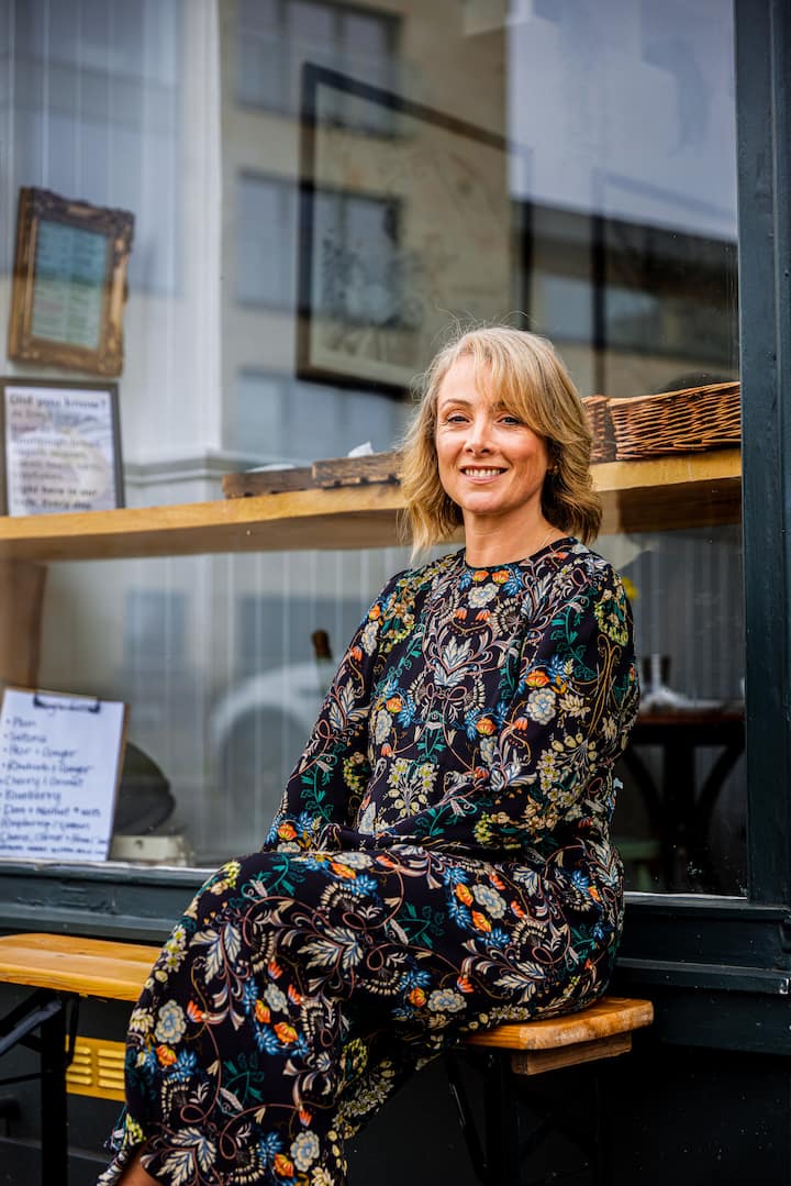 Image of Catherine smiling outside a cafe