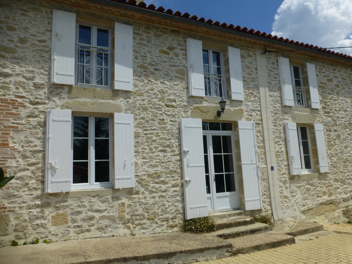 Longère en pierres au milieu d'un parc arboré