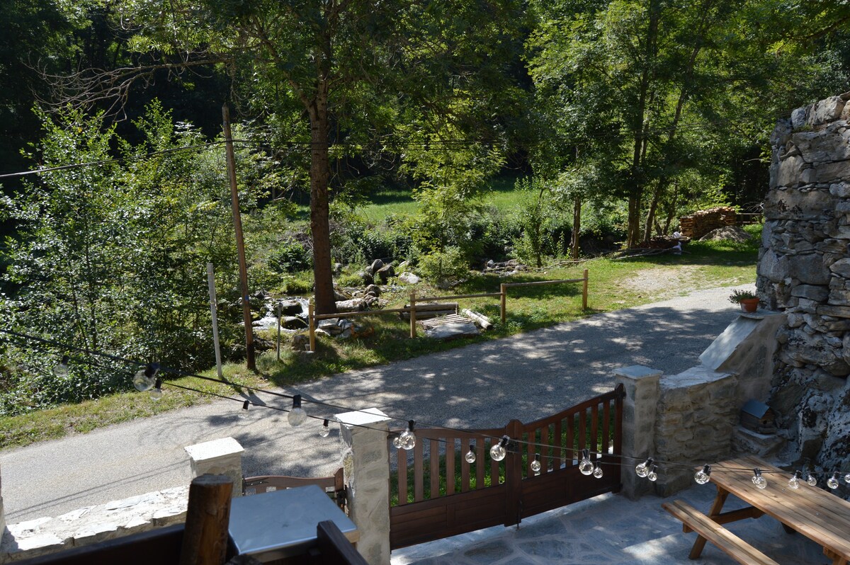 Maison en pierre, jardin avec rivière, montagne