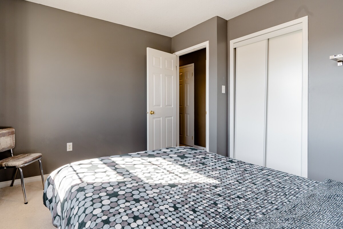 一间宽敞舒适的灰色卧室，位于一栋大住宅内