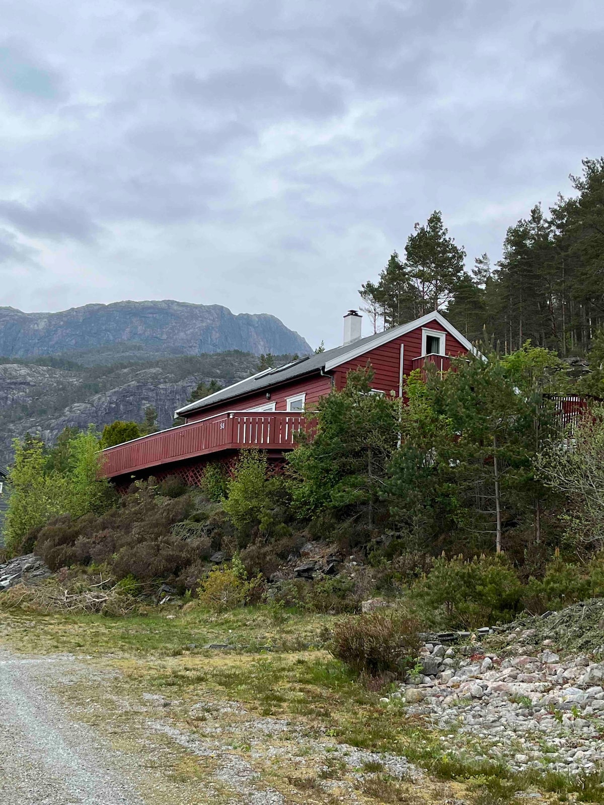 Hytte nær fjord fjell og fonn