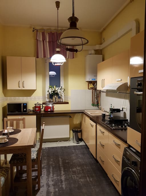 fully fitted kitchen with microwave, stove, hob, washing machine