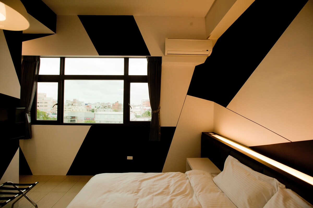 街景雙人房：位於鬧中取靜的巷弄，黑白純色的簡單，搭配舒壓的加大雙人床