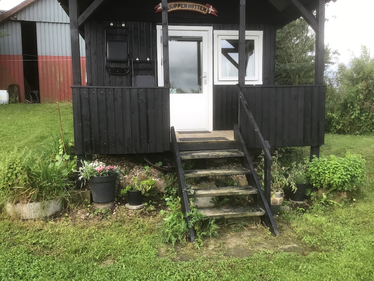 Tiny House mellem fjord og hav.