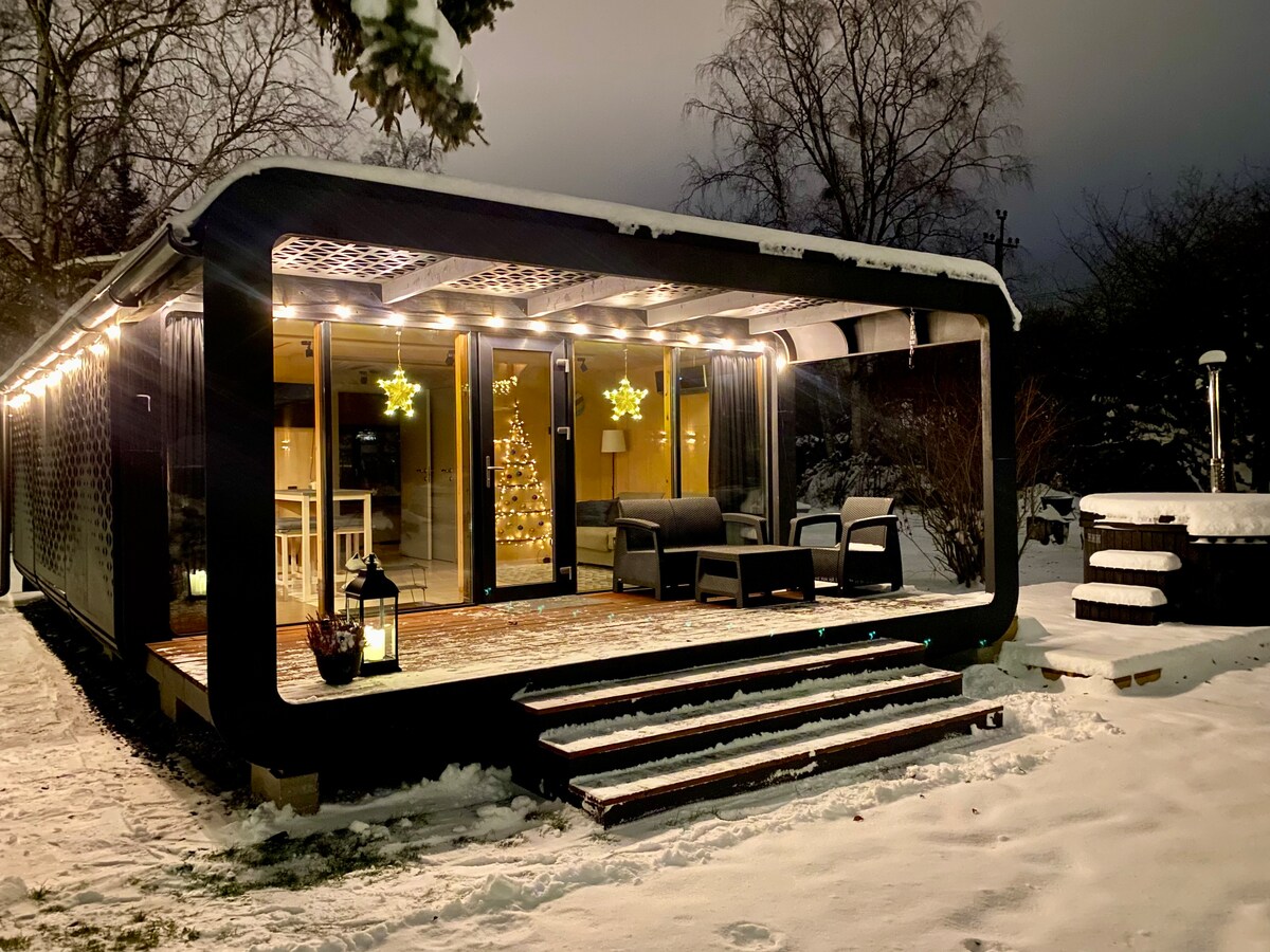 A tiny house with a garden and a hot tube