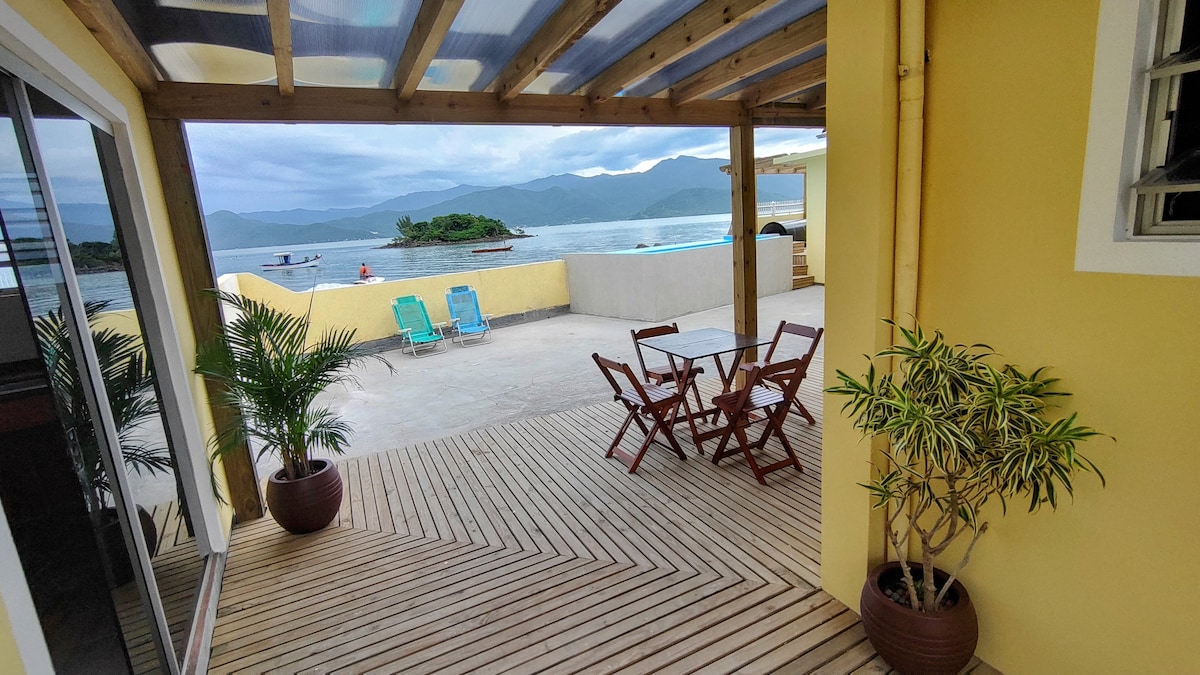 Beira-mar, piscina e vista montanha com pôr do sol