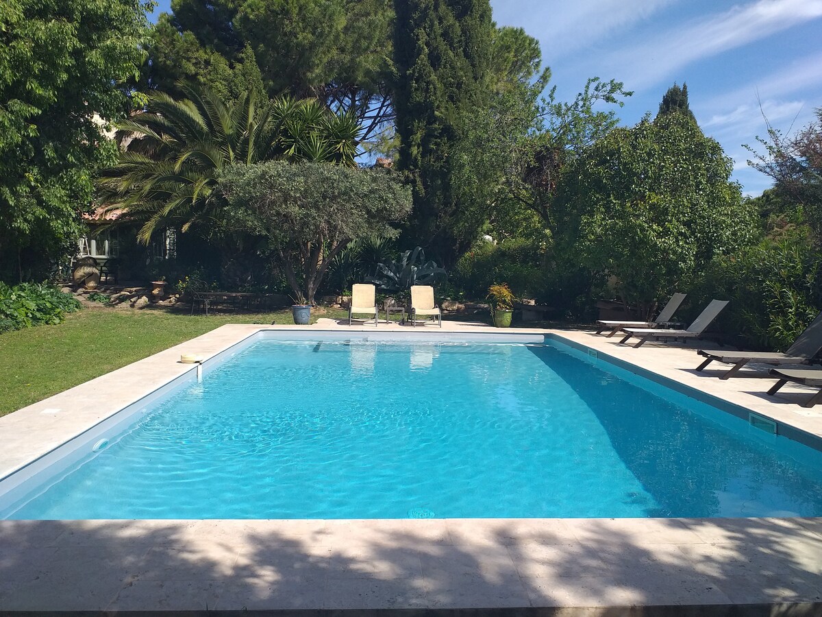 Tiny house dans parc arboré avec vue sur piscine.