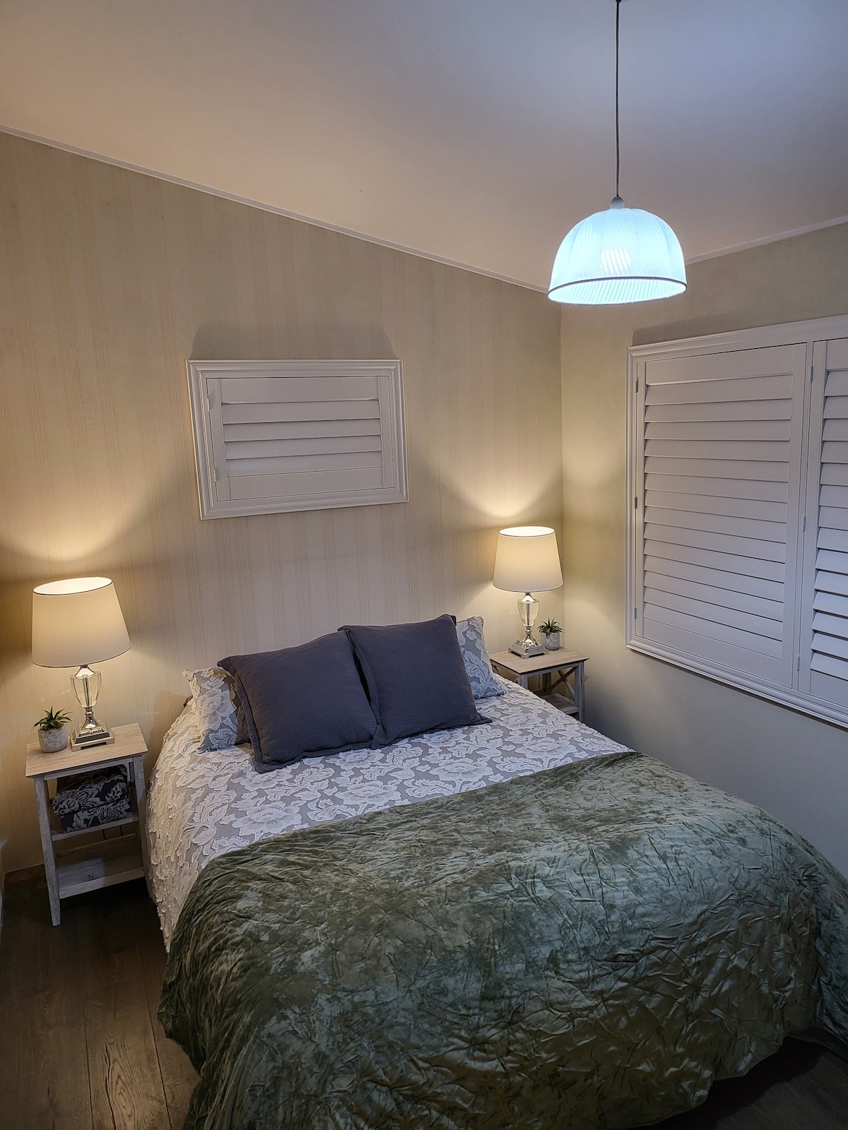 阳光明媚的卧室，配有舒适的标准双人床，位于