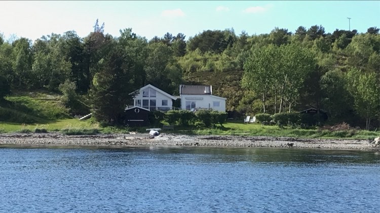 Barnevennlig hytte ved sjøen med båt.