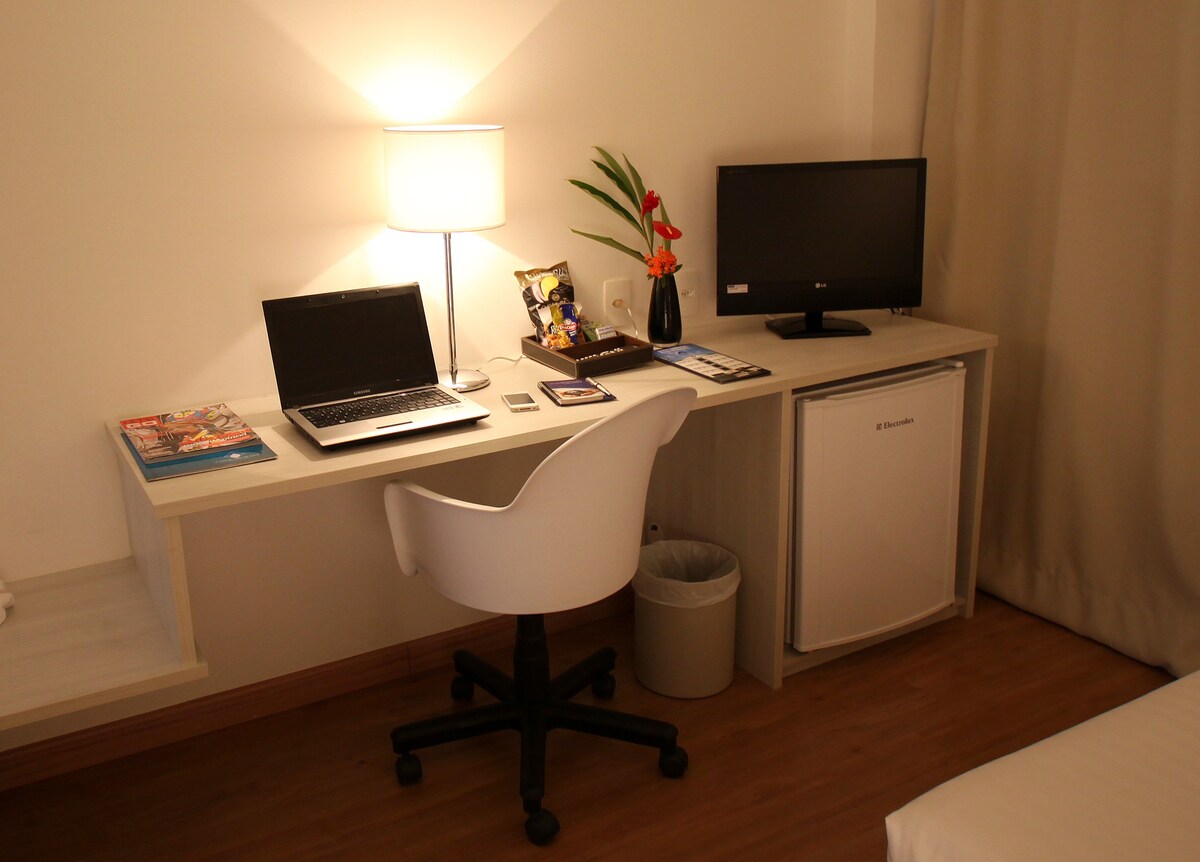 Quarto com internet e mesa para notebook no centro