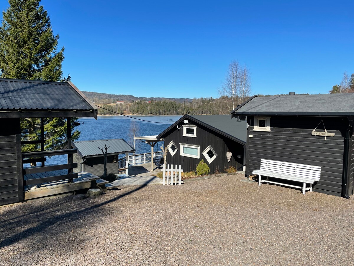 Flott utsikt over innsjø  med  brygge og badeplass