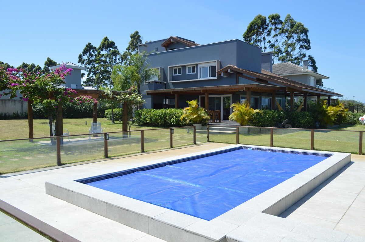 Casa 4 suítes condomínio beira Lagoa de Ibiraquera