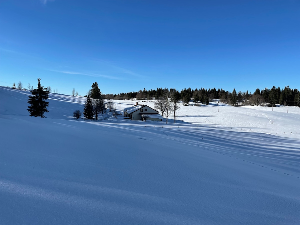 Maison isolée sur piste ski de fond avec cheminée.