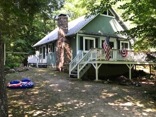 带甲板的舒适湖泊通道小屋。