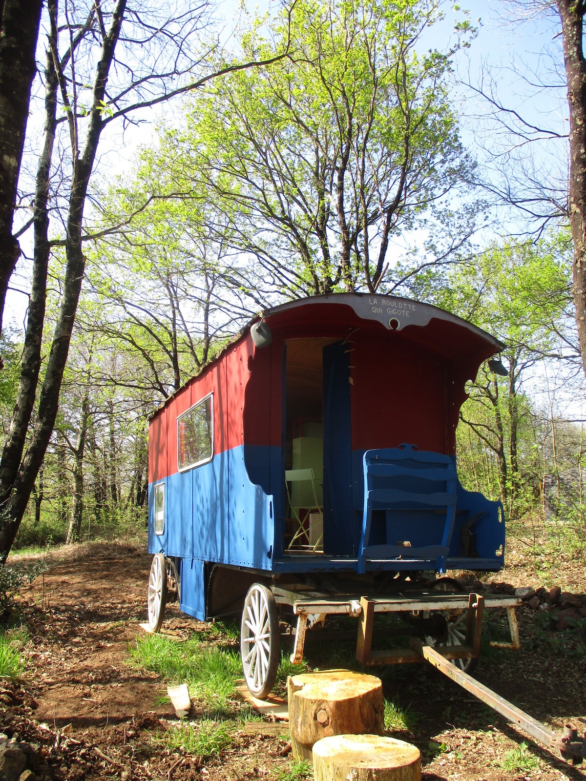 Roulotte sous les arbres dans camping à la ferme