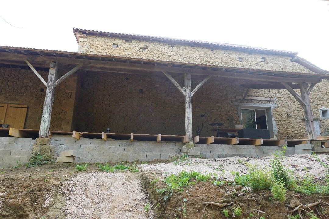 Ferme traditionnelle avec murs en pierre et terre.