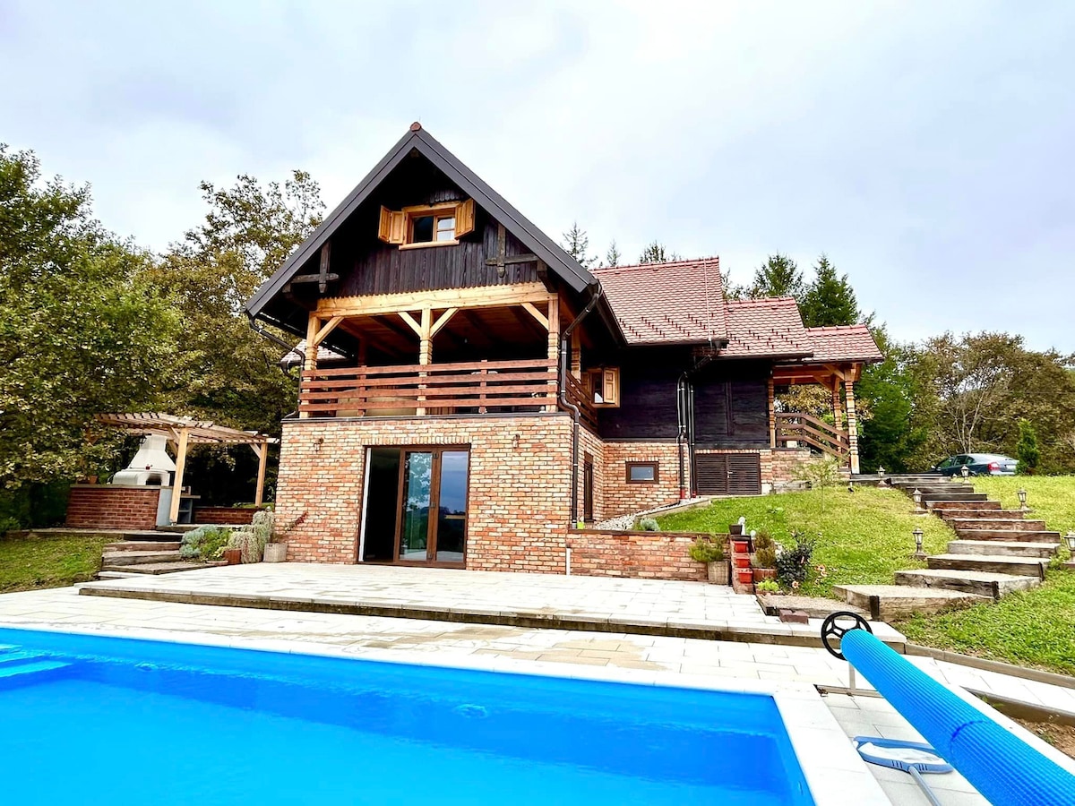 A villa with a pool and hot tub in nature.