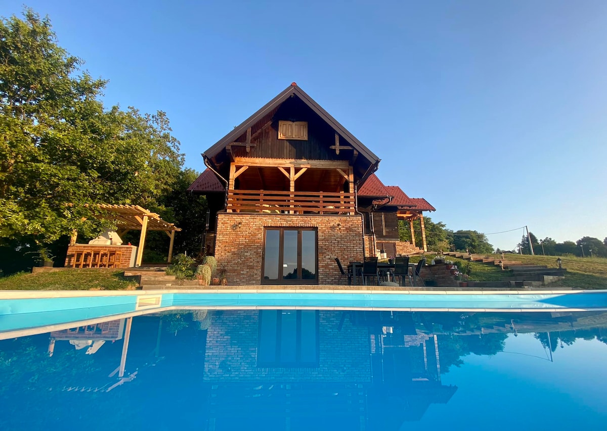 A villa with a pool and hot tub in nature.