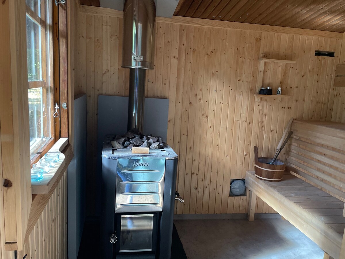 Cottage beside lake with fireplace and sauna.