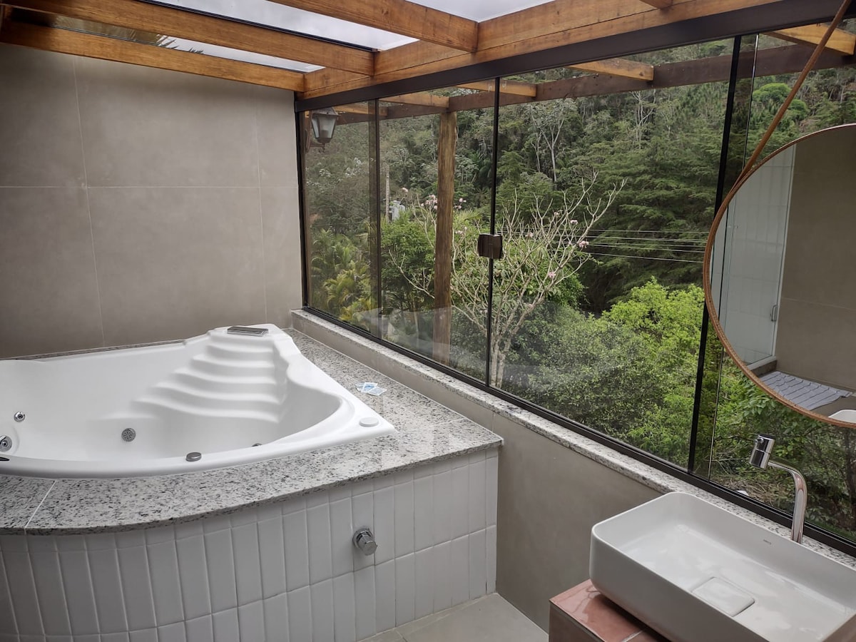带浴缸和森林景观的山间房屋