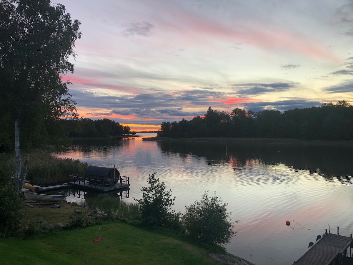 Sjöläge med roddbåt, bastu och stort utedäck.