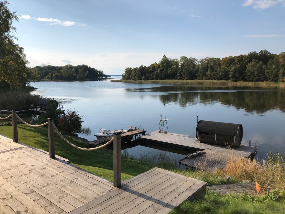 Sjöläge med roddbåt, bastu och stort utedäck.