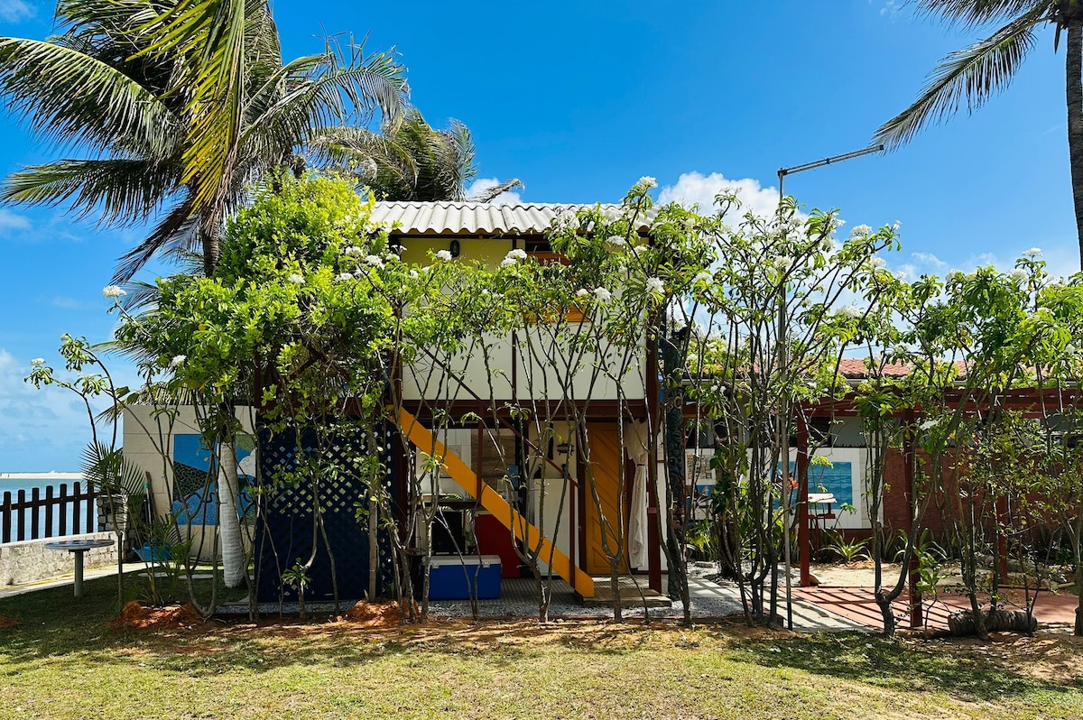 Casinha de madeira entre rio e mar