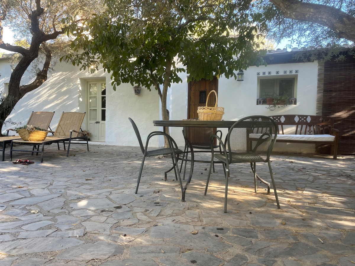 Cortijo con piscina rodeado de montañas.