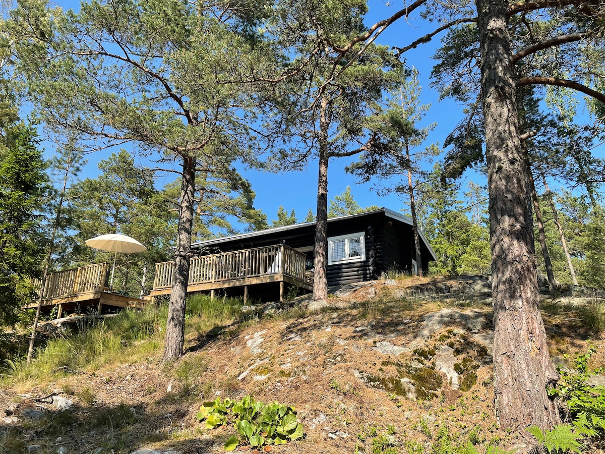 Charmig timmerstuga på naturtomt i skärgården