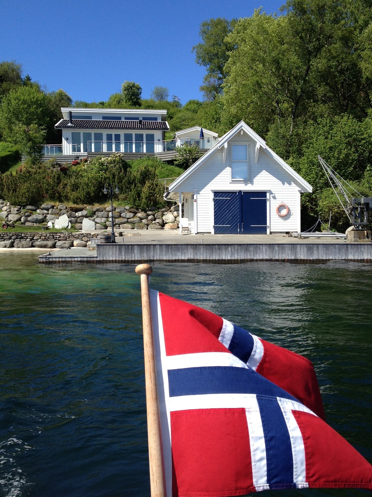 Hytte ved sjøen med privat brygge og strand.