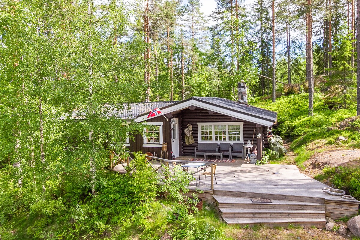 Uriges Blockhaus im Wald mit Boot