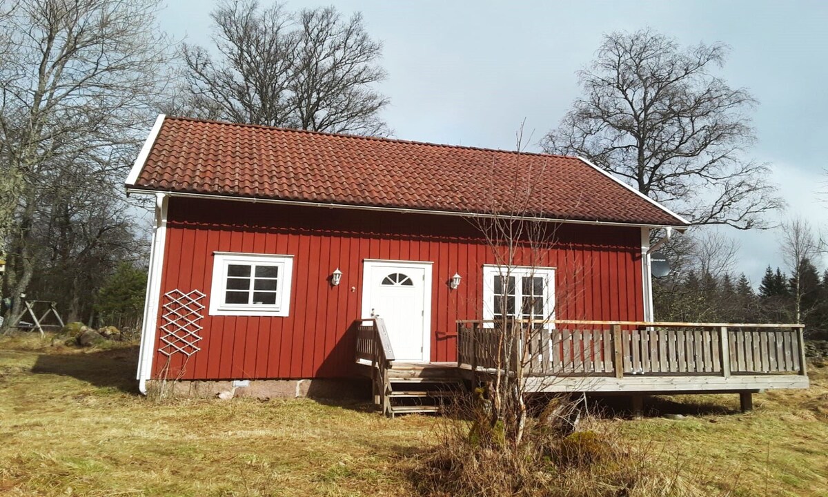 Cozy red cottage with white knots outside Lenhovda