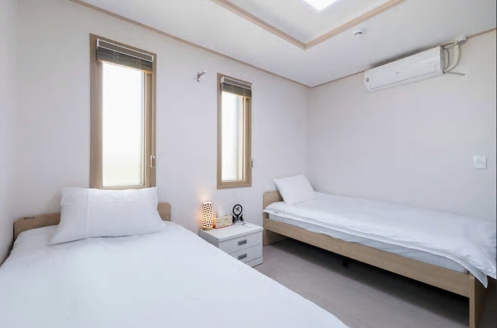 简洁的白色和木色组合的小型双人房。