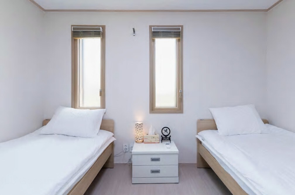 简洁的白色和木色组合的小型双人房。