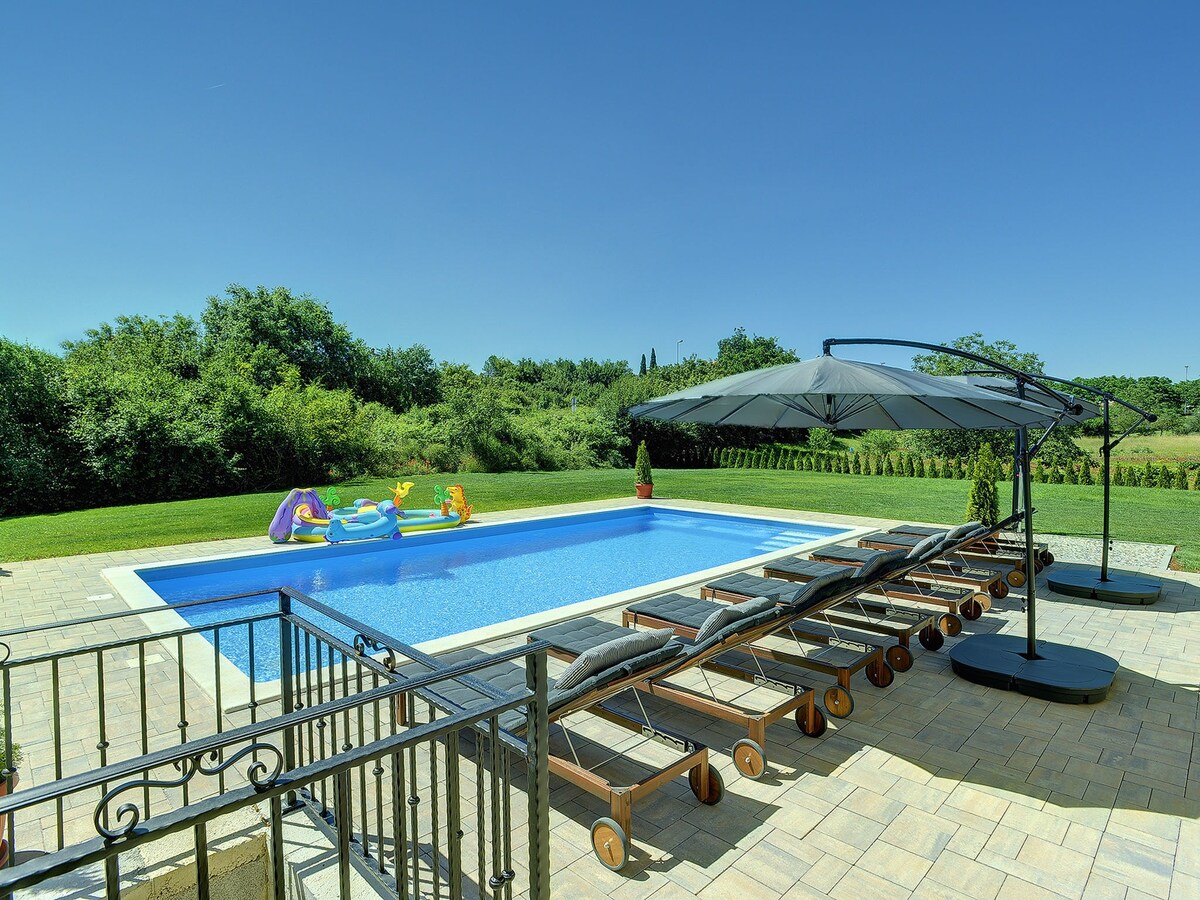 宽敞的别墅，带泳池和阳伞，位于罗维尼